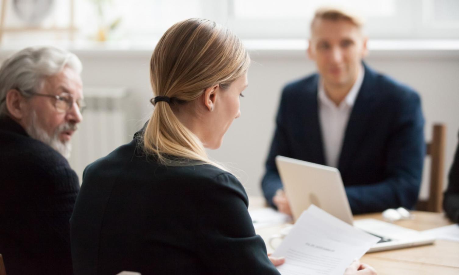 Person arbeitet konzentriert an Finanzplanung mit Dokumenten und Taschenrechner